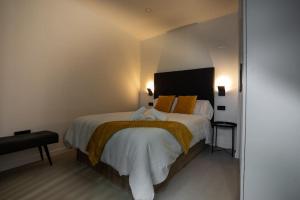 a bedroom with a bed with white sheets and orange pillows at Loft 11 B in Murcia