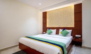 a bedroom with a large white bed with green pillows at Itsy By Treebo - Meraki Grand in Gangtok