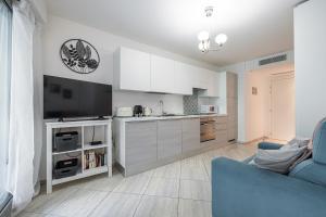 un salon avec un canapé bleu et une cuisine dans l'établissement Studio Centre Terrasse Climatisation 50m plage, à Menton