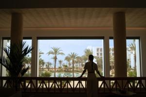 Una mujer mirando por la ventana de un edificio en The View Agadir, en Agadir