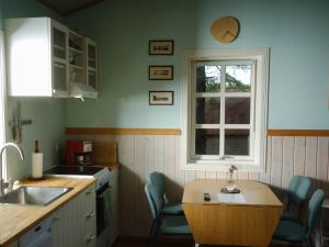 a kitchen with a table and chairs and a window at Backyard Village in Hveragerði