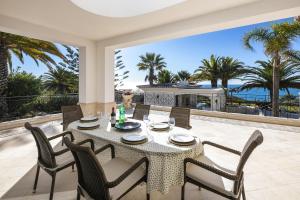 a table and chairs on a patio with a view of the ocean at Casa Ceu Branco in Carvoeiro