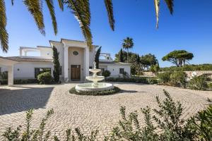 a large house with a fountain in the middle of a courtyard at Casa Ceu Branco in Carvoeiro +10 photos