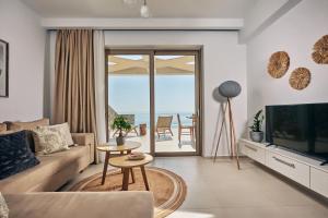 a living room with a couch and a television at Thelxi's Suite II - Brand New Seaview Suite! in Volimes