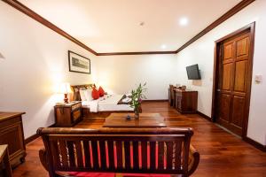 1 dormitorio con 1 cama y 1 mesa en una habitación en Royal Crown Hotel Siem Reap, en Siem Reap