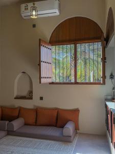 a living room with a couch and a window at بيت أرض الثراء Rich Land House in Nizwa