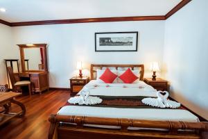 a bedroom with a large bed with red pillows at Royal Crown Hotel Siem Reap in Siem Reap