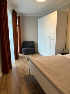 1 dormitorio con 1 cama, armario y silla en New apartment 6 - self check in, free parking, en Bratislava