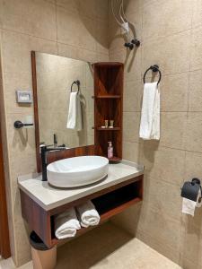 ein Bad mit einem Waschbecken und einem Spiegel in der Unterkunft بيت أرض الثراء Rich Land House in Nizwa