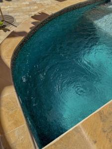 a swimming pool with blue water in a yard at بيت أرض الثراء Rich Land House in Nizwa