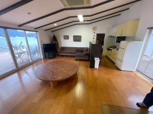 een woonkamer met een tafel en een keuken bij Sea Garden Villa Shodoshima in Kusakabe