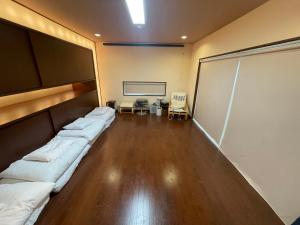 een kamer met 2 bedden voor een projectiescherm bij Sea Garden Villa Shodoshima in Kusakabe