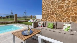 La Guirra的住宿－CASA LOTTIE，一个带沙发和桌子的庭院,毗邻一个游泳池