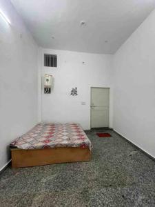 a bedroom with a bed and a door in a room at Rukmani Villas Group of Rukmani home stay in Mathura