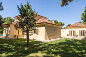 een groot huis met een groen gazon ervoor bij Aurelia Villa by CadenzaLux in Cascais