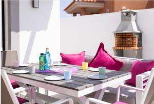 La Guirra的住宿－CASA LOTTIE，餐桌和粉红色枕头