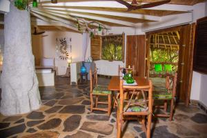 a dining room with a table and chairs at Bottle Cottage in Shimoni