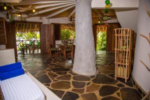 a room with a column and tables and chairs at Bottle Cottage in Shimoni