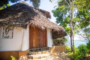 a small hut with a thatched roof at Bottle Cottage in Shimoni
