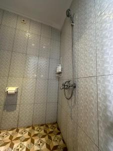 La salle de bains est pourvue d'une douche avec une porte en verre. dans l'établissement Nang Taro Home Stay, à Penginyahan