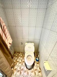- une petite salle de bains avec toilettes dans une cabine dans l'établissement Nang Taro Home Stay, à Penginyahan