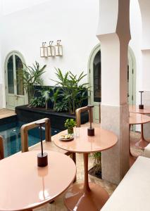 a restaurant with two tables and a pool at Riad Al Uzza in Marrakesh