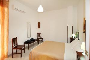 Habitación de hotel con 1 cama y 2 sillas en Appartamento con Cortile Privato, en Santo Stefano di Camastra