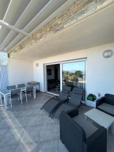 Una sala de estar con un sofá y sillas y una mesa. en Résidence Paolina, en LʼÎle-Rousse