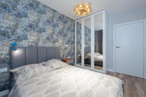 1 dormitorio con 1 cama grande y espejo en Luxury in City -12- Free Parking, en Łódź