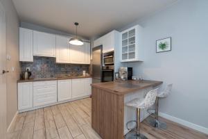 a kitchen with white cabinets and a wooden counter top at Luxury in City -12- Free Parking in Łódź