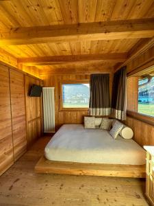 a bedroom with a bed in a wooden cabin at Agriturismo La Stalla in Bormio +56 photos