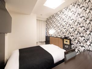 東京にあるアパホテル〈TKP東京西葛西〉の黒と白の模様の壁、ベッド付きのベッドルーム1室