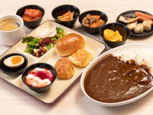 una mesa con un plato de comida y tazones de comida en APA Hotel TKP Tokyo Nishi-Kasai en Tokio
