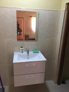 ein Badezimmer mit einem weißen Waschbecken und einem Spiegel in der Unterkunft pesalai plvillas in Pesalai
