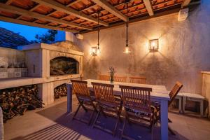 an outdoor patio with a table and a fireplace at Villa Komelo in Škrip