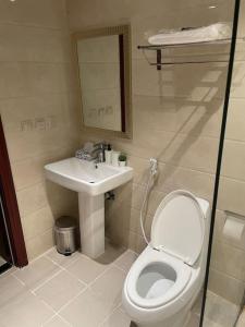 uma casa de banho com um WC e um lavatório em شقة انيقة بموقع مميز ودخول ذاتي em Dhahran