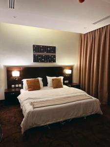 1 dormitorio con 1 cama grande y 2 almohadas en شقة انيقة بموقع مميز ودخول ذاتي, en Dhahran