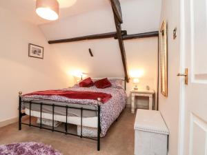 une chambre avec un lit avec des oreillers rouges dessus dans l'établissement Black Sheep Cottage, à Thirsk