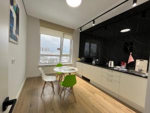 a kitchen with a table and two chairs and a counter at RAISSON A-HOTELG32 KHAN SHATyR in Astana