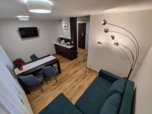 a living room with a blue couch and a table at Boutique Hotel's III Piłsudskiego in Łódź