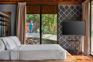 een slaapkamer met een bed en een groot raam bij The Namkhan in Luang Prabang