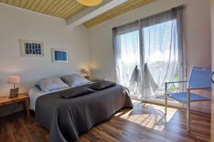 1 dormitorio con cama y ventana grande en Capucines et agapanthes en Saint-Nic