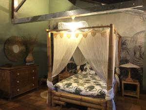 una camera con letto a baldacchino e luce di Maison à 10 min du puy du fou et parc de Maulévrier a Saint-Amand-sur-Sèvre