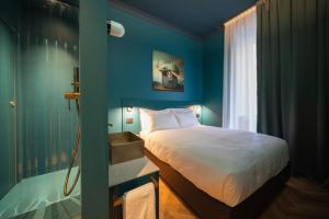 a bedroom with a bed and a blue wall at Fontana 16 Rooms in Milan