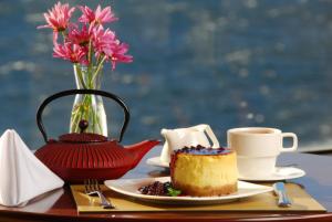 a table with a plate of cake and a cup of coffee at Alma Del Lago Suites & Spa in San Carlos de Bariloche