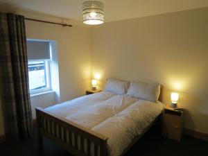 een slaapkamer met een bed met twee verlichting bij The Heritage Guest House in Montrose