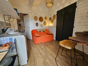 una cucina con divano arancione in una camera di Canne Mapou, l'Escale Nature a Trois Bassins