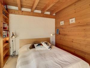 uma cama num quarto com uma parede de madeira em Aphrodite 006 em Verbier