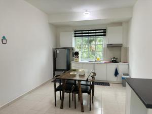 a kitchen with a table and chairs and a refrigerator at Home Feel-Camellia Suites in Kampar