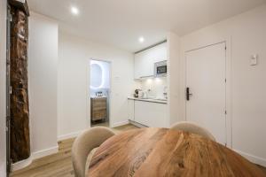 ein Esszimmer mit einem Holztisch und Stühlen in der Unterkunft Encantador apartamento Plaza del Callao in Madrid